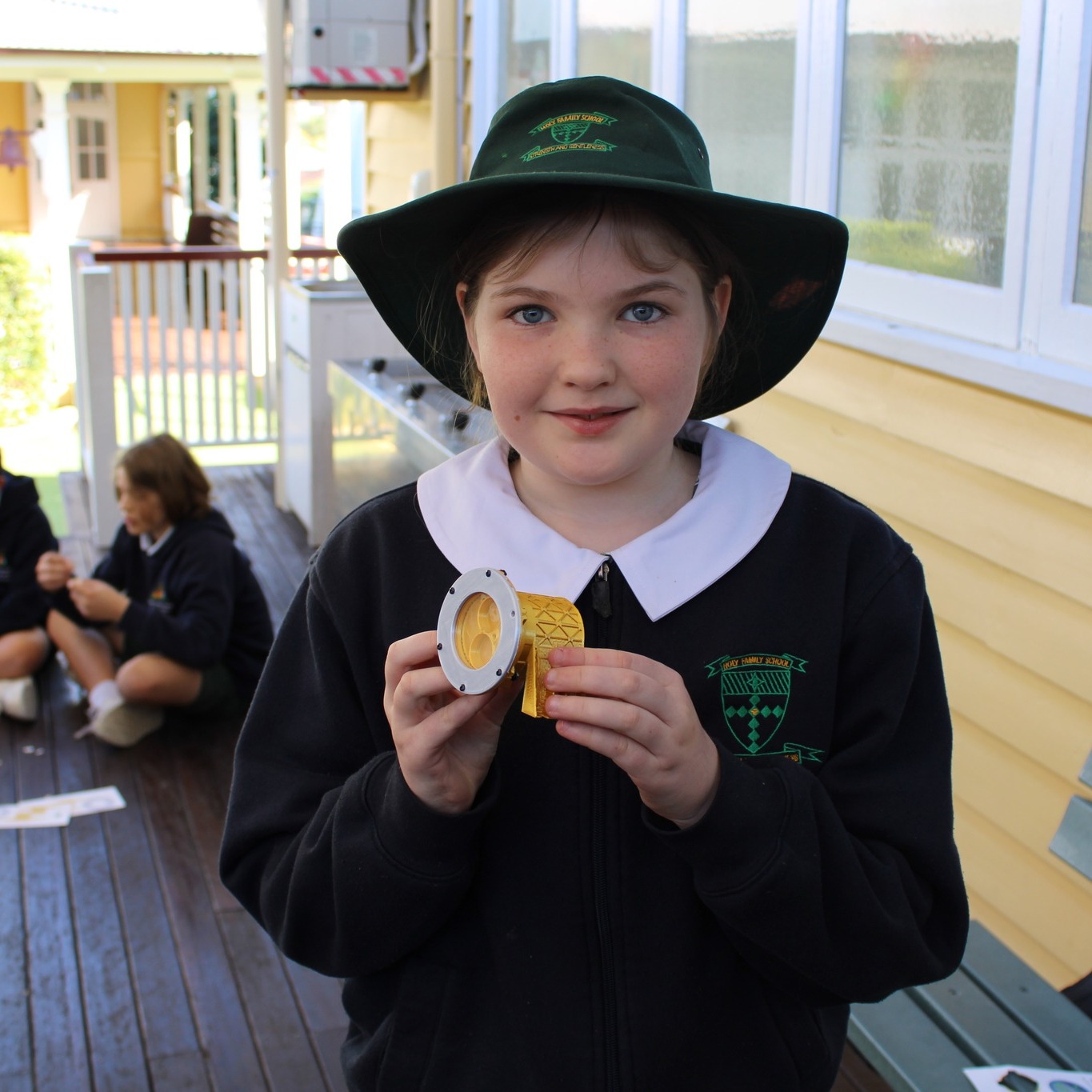 Student holding a hands‑on science model, highlighting learning in space science and quantum technology through curiosity, experimentation and future‑focused inquiry